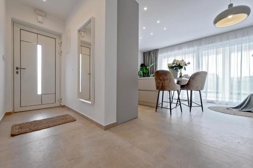 a living room with a table and chairs and a door at Luxury Villa Del Sogno with pool, jacuzzi, parking in Trogir