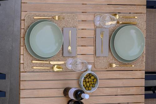 a table with plates and forks and knives and aeder at Luxury Villa Del Sogno with pool, jacuzzi, parking in Trogir
