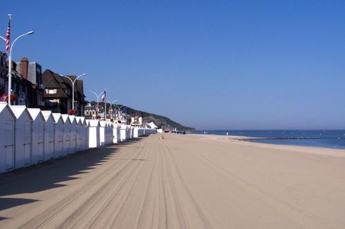 une plage de sable avec une clôture et l'océan dans l'établissement la plage location a la semaine samedi au samedi, à Villers-sur-Mer