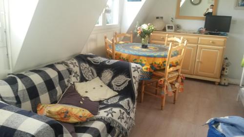 un salon avec un canapé et une table dans l'établissement la plage location a la semaine samedi au samedi, à Villers-sur-Mer