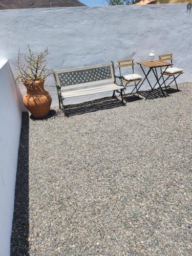 a bench and two chairs and a table and a plant at Villa MIA 2.0 in Giniginámar