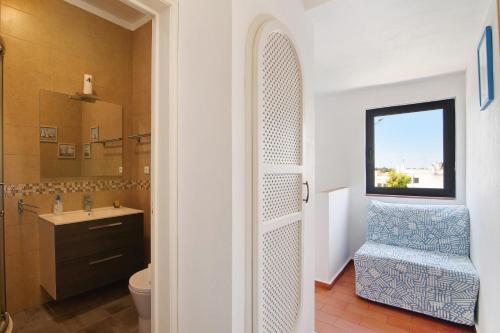 Un baño con inodoro y ventana. en Typical Algarve Almargem 75, en Conceição