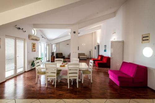 a dining room and living room with a table and chairs at Prijevor Apartments in Budva