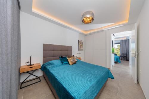 a bedroom with a bed with a blue comforter at Apartman SeaSide 8 in Banjole