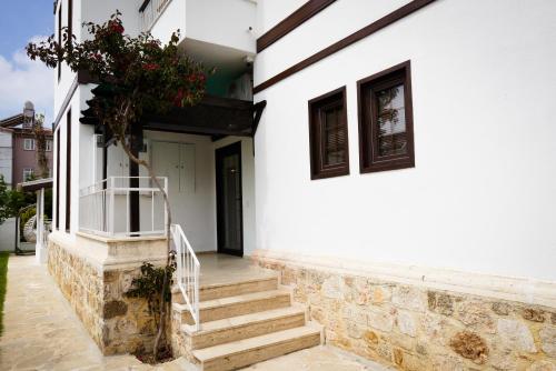 a white house with stairs and flowers on it at Villa Hania Boutique Hotel - Adults only in Side