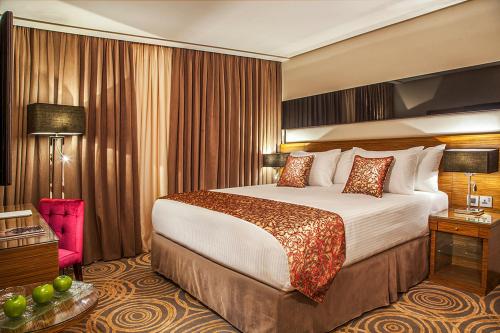 um quarto de hotel com uma cama grande num quarto em Harir Palace Hotel em Amã
