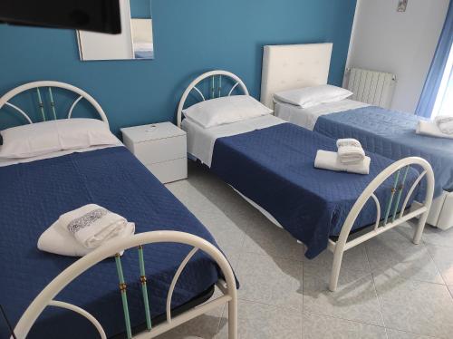 Duas camas num quarto com paredes azuis em La casa di Anna em Villabate
