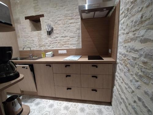 a kitchen with a sink and a stone wall at Chambres Résidentielles avec cuisine au Manoir de Mathan à Crépon 5 mn D'Arromanches et 10 mn de Bayeux in Crépon