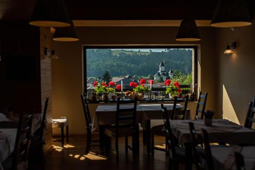 a dining room with a table with flowers on it at Bucovina Lodge Pension in Vama