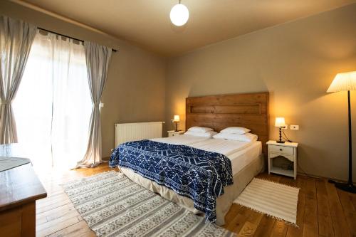 a bedroom with a bed and a large window at Bucovina Lodge Pension in Vama