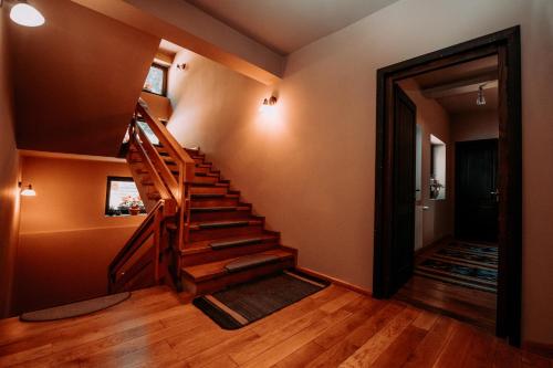 a hallway with a wooden staircase in a house at Bucovina Lodge Pension in Vama