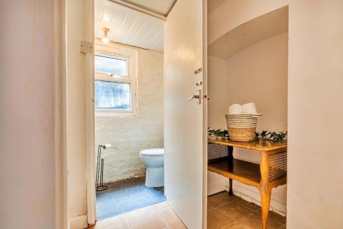 a bathroom with a toilet and a wooden table at Finest Retreats - George Street in Grantham