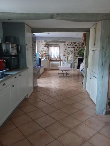 a kitchen and living room with a tile floor at Maison de village in Sourribes