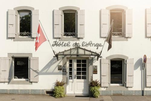 Ein weißes Gebäude mit einem Schild, das Hotel des Universums liest in der Unterkunft Hôtel de l'Ange in Nyon