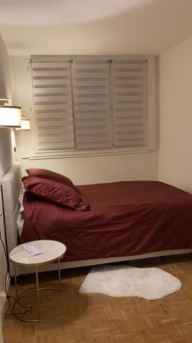 une chambre avec un lit, une table et une fenêtre dans l'établissement 2pièces meublé Proche Paris et métro, à Maisons-Alfort