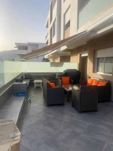 un patio avec des canapés et des chaises dans un bâtiment dans l'établissement Appartement 3chambres avec piscine, à Agadir nʼ Aït Sa