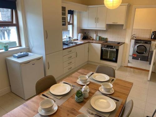 uma cozinha com uma mesa de madeira com placas em Beautiful 3 Bedroom House in Coolaney Village County Sligo 