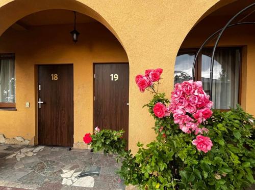 a house with two doors and flowers on the side at Hotel U Grubego in Wielogóra