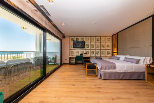 um quarto com uma cama grande e uma varanda em Hotel Antonio II em Zahara de los Atunes