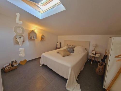 une chambre avec un grand lit avec une lucarne dans l'établissement Splendide vue mer, à Sanary-sur-Mer
