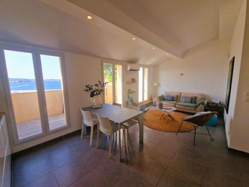 un salon avec une table, des chaises et un canapé dans l'établissement Splendide vue mer, à Sanary-sur-Mer