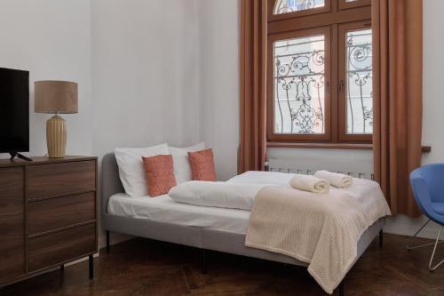 a bedroom with a bed with a dresser and a window at 350m to the Market Square - Św Antoniego Apartment by Renters in Wrocław