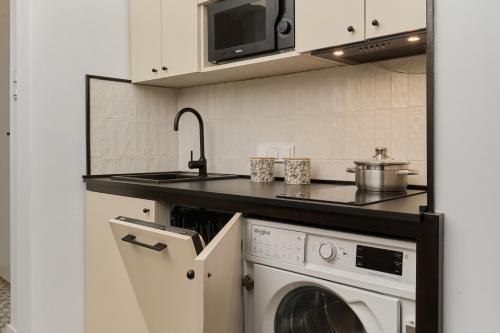 a kitchen with a sink and a washing machine at 350m to the Market Square - Św Antoniego Apartment by Renters in Wrocław