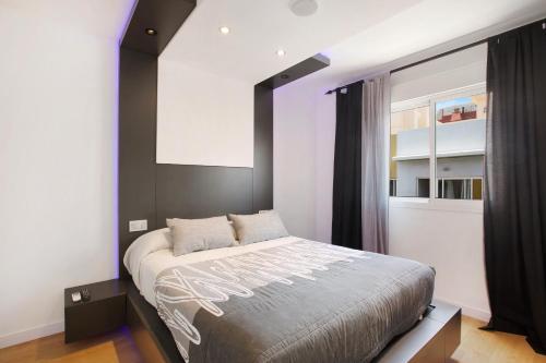 a bedroom with a large bed with a black headboard at Piso Moderno in Candelaria