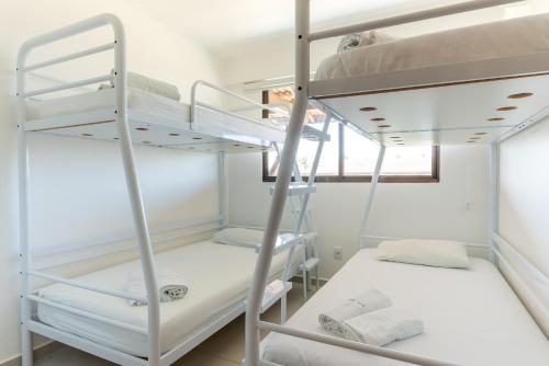 um quarto com 2 beliches e uma janela em Flat 2 quartos em Porto, Cupe Beach Living (pé na areia). em Porto de Galinhas