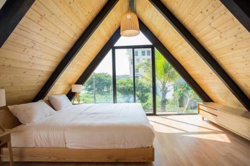 een slaapkamer met een groot bed en een groot raam bij Monkey Mountain Villa Retreat 1 in Da Nang