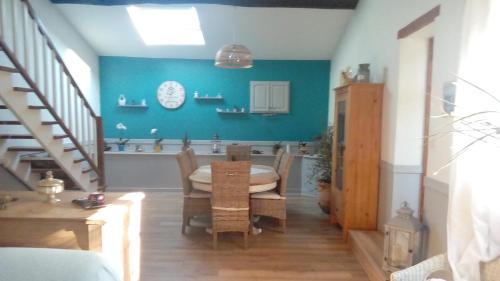 uma sala de jantar com uma mesa e uma parede azul em Chambre d'hôtes Les Nénuphars em Melle
