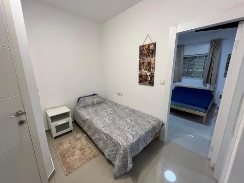 a bedroom with a bed and a blue chair at בית מרום in Gan Shomeron