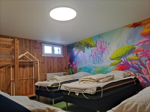 a room with three beds and a painting on the wall at Maison avec piscine privée, proche plage in Avrillé
