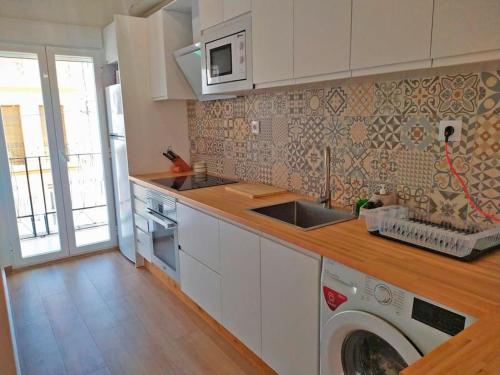 a kitchen with a washing machine in the counter top at Piso recién reformado con gran terraza in Xeraco