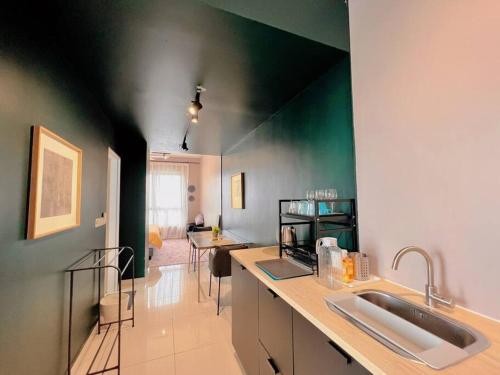 a kitchen with two sinks and a green wall at Studio Staycation D'Sara @ Linked MRT, Near Thomson Hospital & Sungai Buloh Hospital in Sungai Buluh