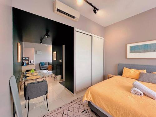 a bedroom with a bed and a desk and a kitchen at Studio Staycation D'Sara @ Linked MRT, Near Thomson Hospital & Sungai Buloh Hospital in Sungai Buluh