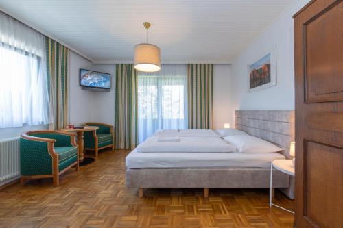 Schlafzimmer mit einem Bett, einem Tisch und Stühlen in der Unterkunft Tirolerhof in Sankt Georgen im Attergau