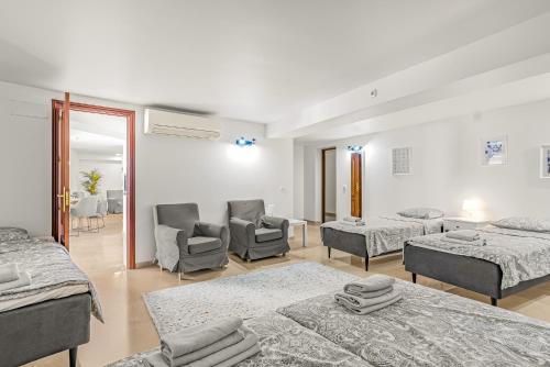 een slaapkamer met 2 bedden en stoelen in een kamer bij Villa Torremimosas in Fuengirola