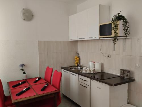 a small kitchen with red chairs and a sink at Apartment Josipa in Dubrovnik