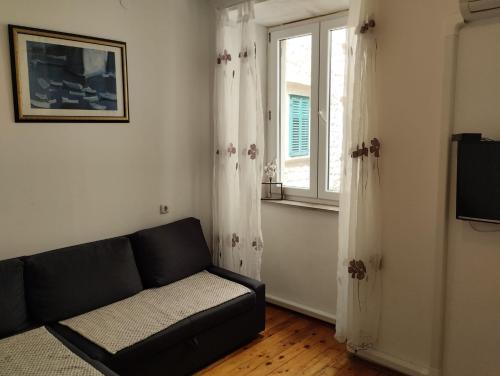 ein Wohnzimmer mit einem Sofa und einem Fenster in der Unterkunft Apartment Josipa in Dubrovnik