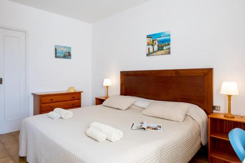 Un dormitorio con una cama blanca con toallas. en Apartmento Cactus II, en Los Cristianos