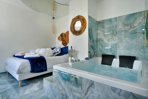ein Badezimmer mit einer Badewanne, einem Bett und einer Badewanne in der Unterkunft welcome to Santorini in Montgeron