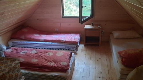 a attic room with two beds and a window at Pasieka Dobro i Smak in Borzymy