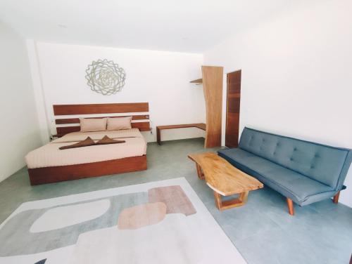 バーン・タイにあるVilla Baan Naí Pãのベッドルーム(ベッド1台、青いソファ付)