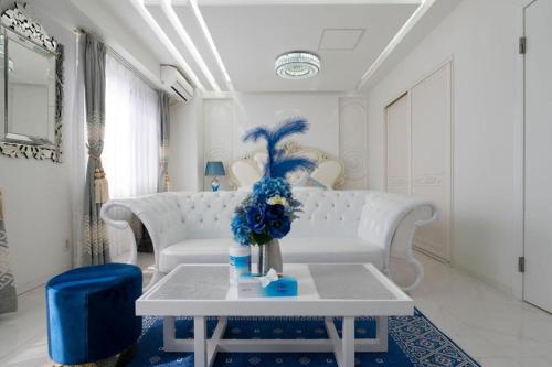 a living room with a white couch and a table with blue flowers at Reimi Mondo9 in Tokyo