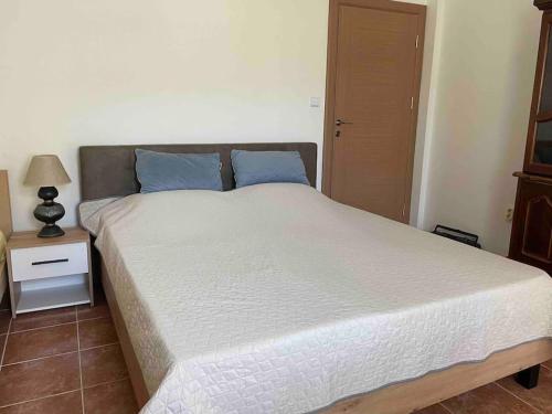 a bedroom with a large bed with blue pillows at Comfortable apartment of 50 square meters in Herceg-Novi