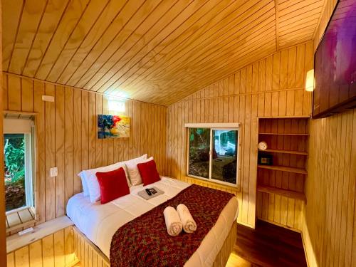 a bedroom with a bed with flip flops on it at Stillner Waldhaus in Puerto Varas