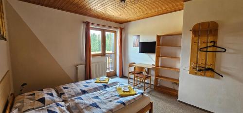 een slaapkamer met een bed, een bureau en een raam bij Horská Kvilda - Ubytování U Chvalů in Horská Kvilda