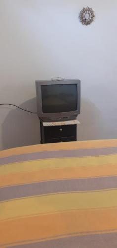 a tv sitting on a stand next to a bed at Casas campestre en un lugar encantador a las faldas del Taita Imbabura in Hacienda Chichavo