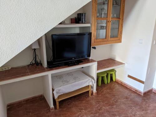 a living room with a tv and a table with a stool at House in Orihuela. Sea view. in Orihuela